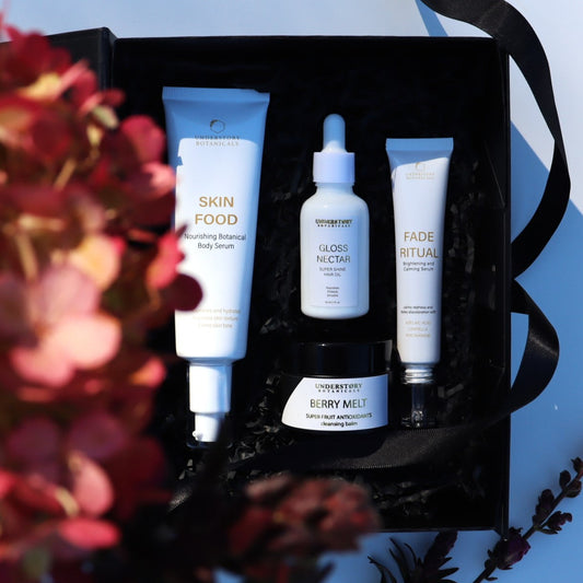 Set of skincare products in a black box with flowers on a blue background